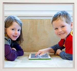 Ein Mädchen und ein Junges bedienen zusammen ein Tablet