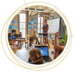Eine Lehrerin steht vor Ihren Grundschülern in der Klasse