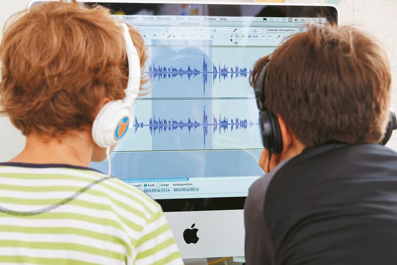 Zwei Jungs schneiden einen Beitrag am Computer