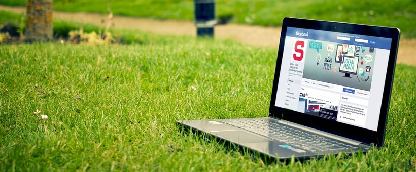 Besucht unsere Fanpage auf Facebook! Ein Notebook mit der offenen scout-Fanpage von Facebook steht auf einer grünen Wiese