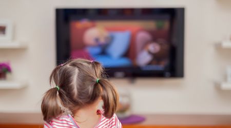 Ansicht von hinten: Ein kleines Mädchen beim Fernsehen