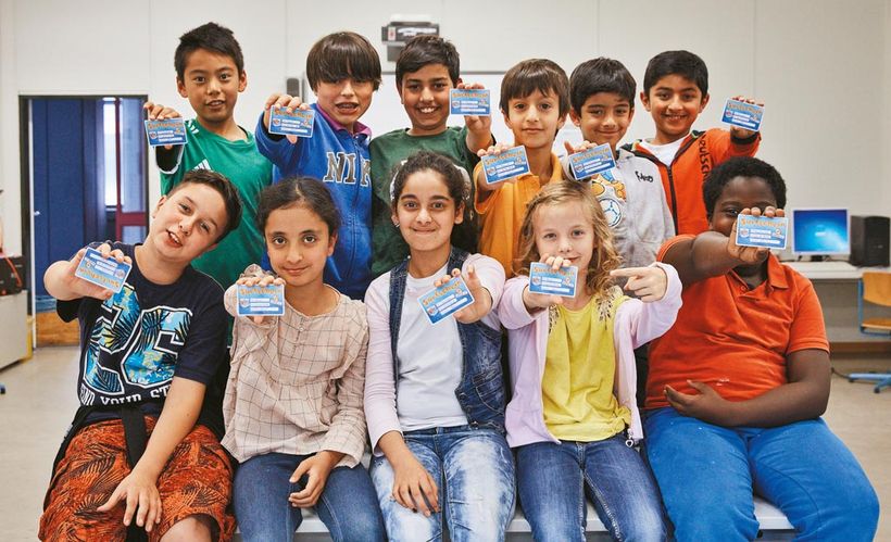 Gruppenfoto der ganzen Klasse mit Surfschein in den Händen