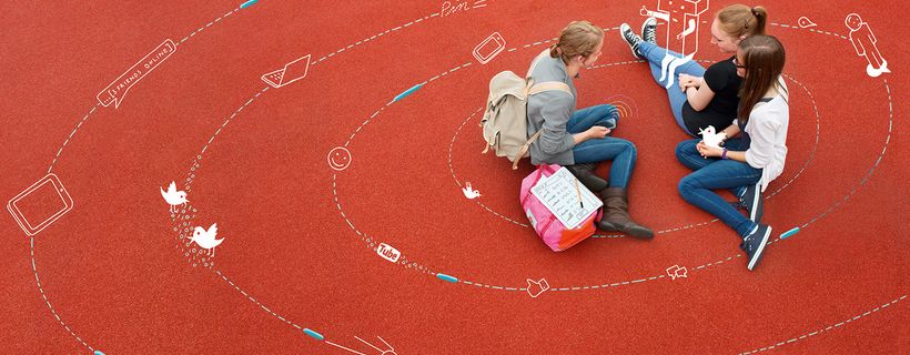 Drei Jugendliche sitzen auf dem Bunden umgeben von Datenkreisen