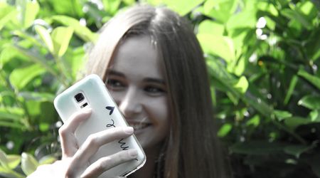 Ein Mädchen hält Ihr Smartphone hoch