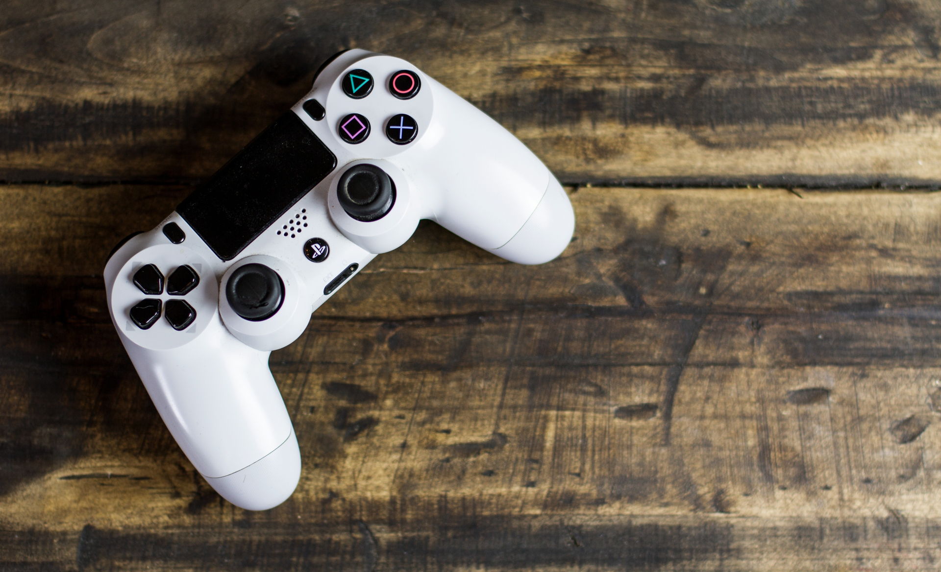 Ein weißer Playstationcontroller auf einer Tischplatte